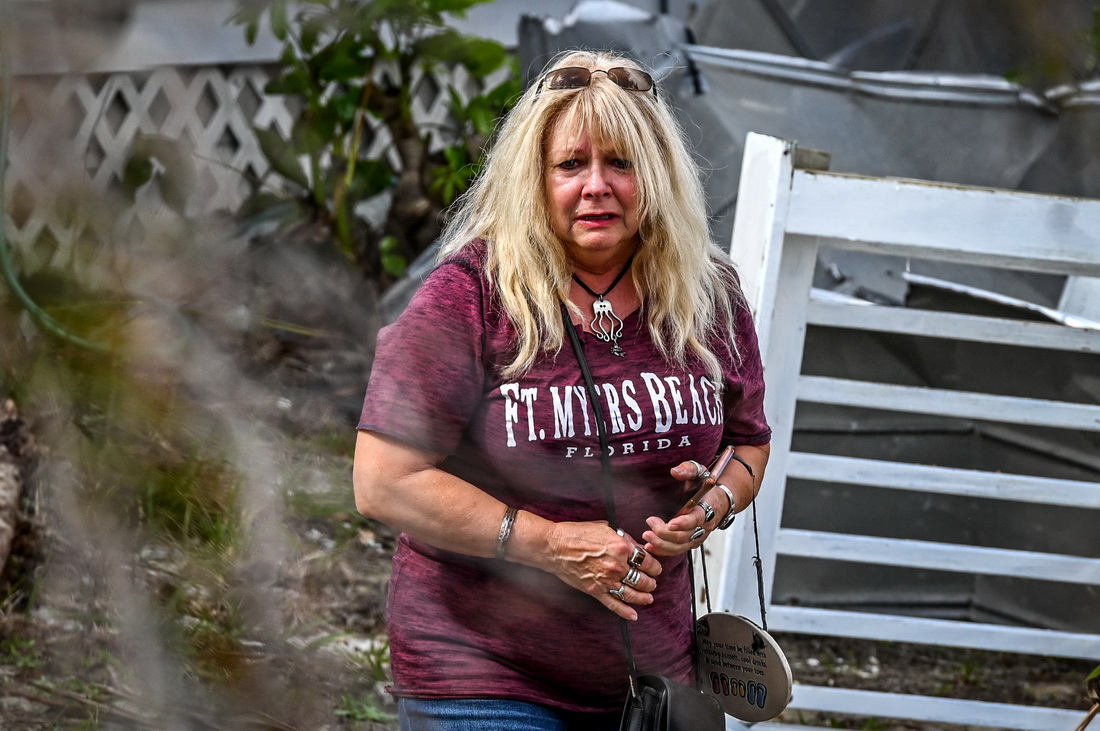 11月7日，在美国佛罗里达州西南部李县，一名女子查看被飓风“伊恩”损坏的房屋。