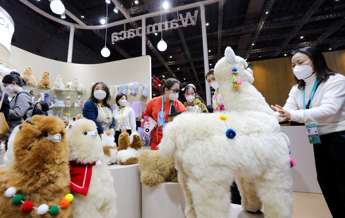 11月8日，參觀者在第五屆進博會“溫暖駝”展台參觀羊駝玩偶。新華社記者 方喆 攝