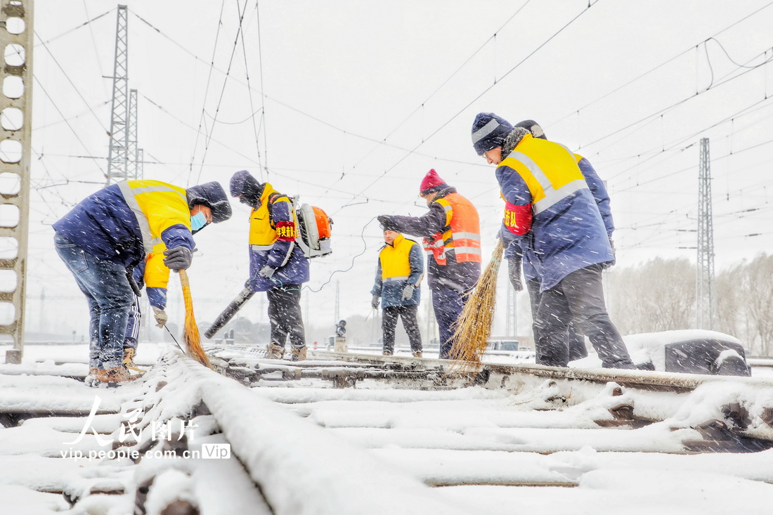 2022年11月12日，中国铁路沈阳局集团有限公司职工清扫道岔积雪，确保铁路运输安全畅通。