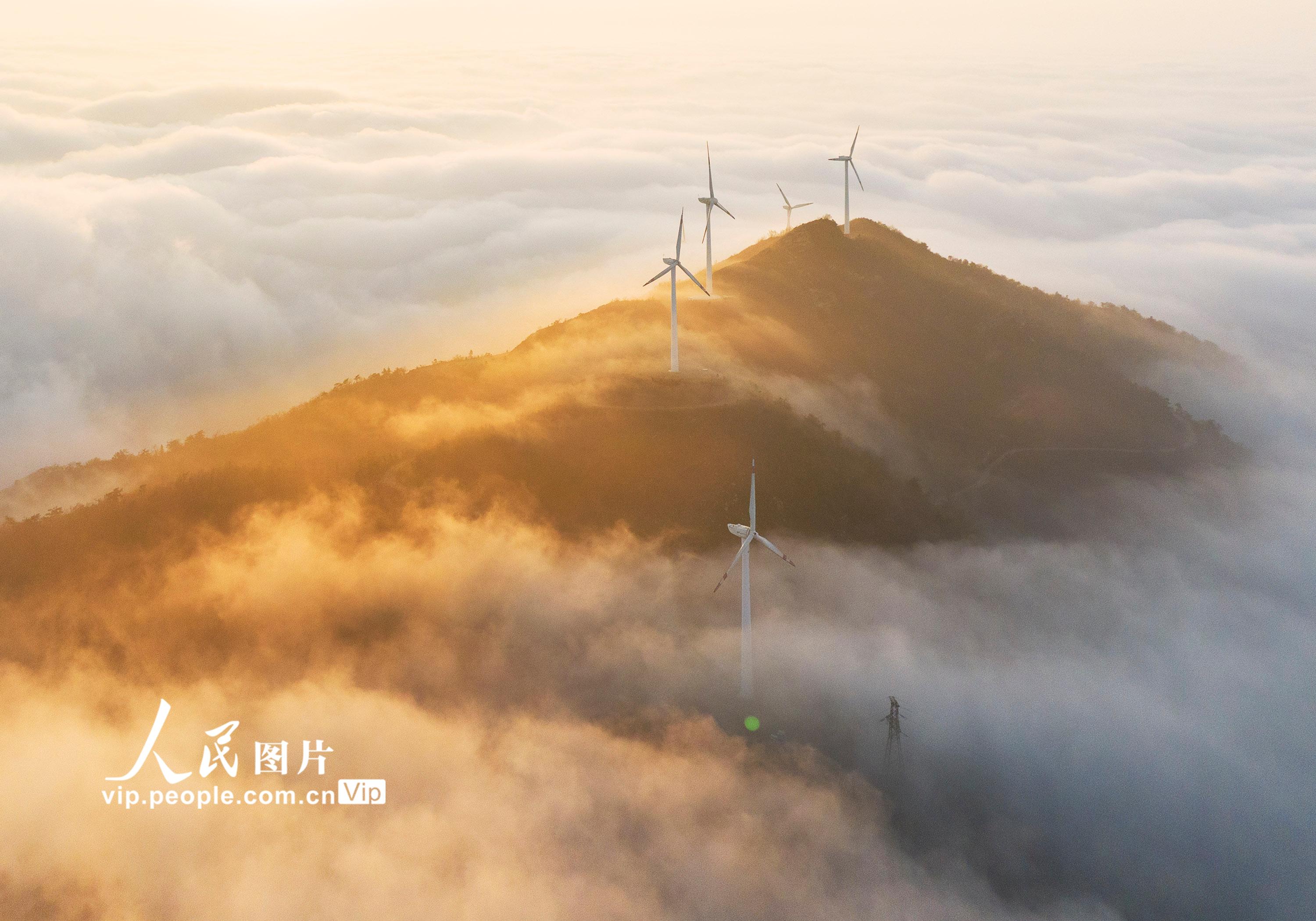 湖北省孝感市大悟县吕王镇仙居顶的风力发电机与云海相映成景。