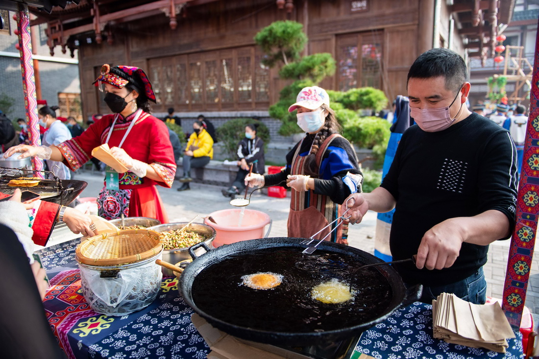 11月19日，工作人員在張家界大庸古城湖南首屆非遺博覽會現場制作美食。