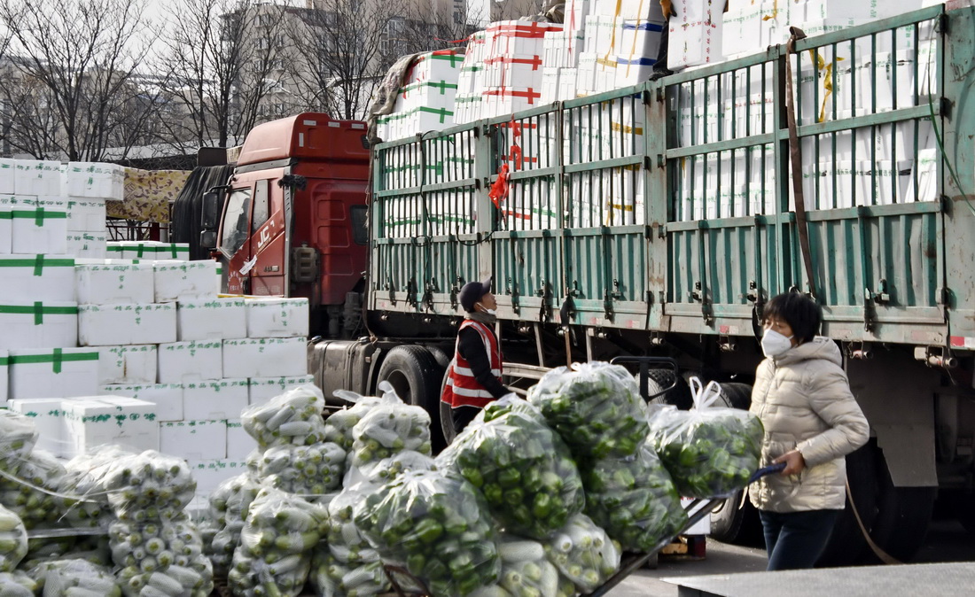 11月28日，新發地市場的商戶在搬運新鮮蔬菜。