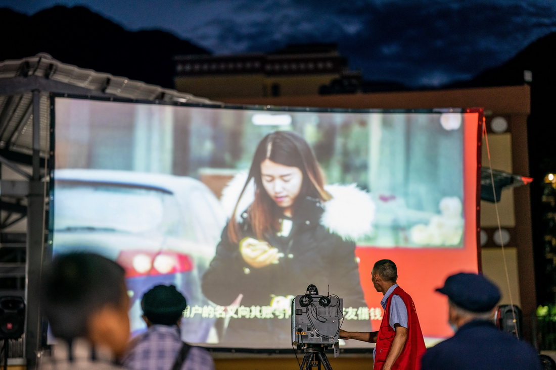 杨明金在怒江州泸水市一个搬迁点播放科教片（2022年10月23日摄）。