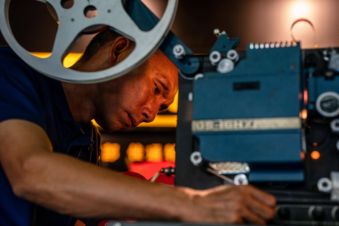 在怒江州泸水市，杨明金修理胶片放映机（2022年10月31日摄）。