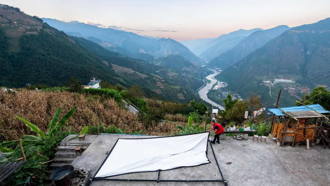 在怒江州泸水市鲁掌镇登梗村，杨明金在安装幕布（2022年10月21日摄）。