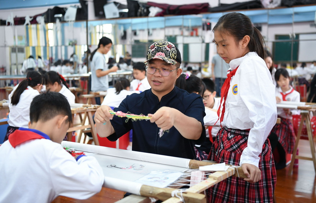 在廣州市荔灣區康有為紀念小學的廣繡課堂，王新元在指導學生（10月12日攝）。