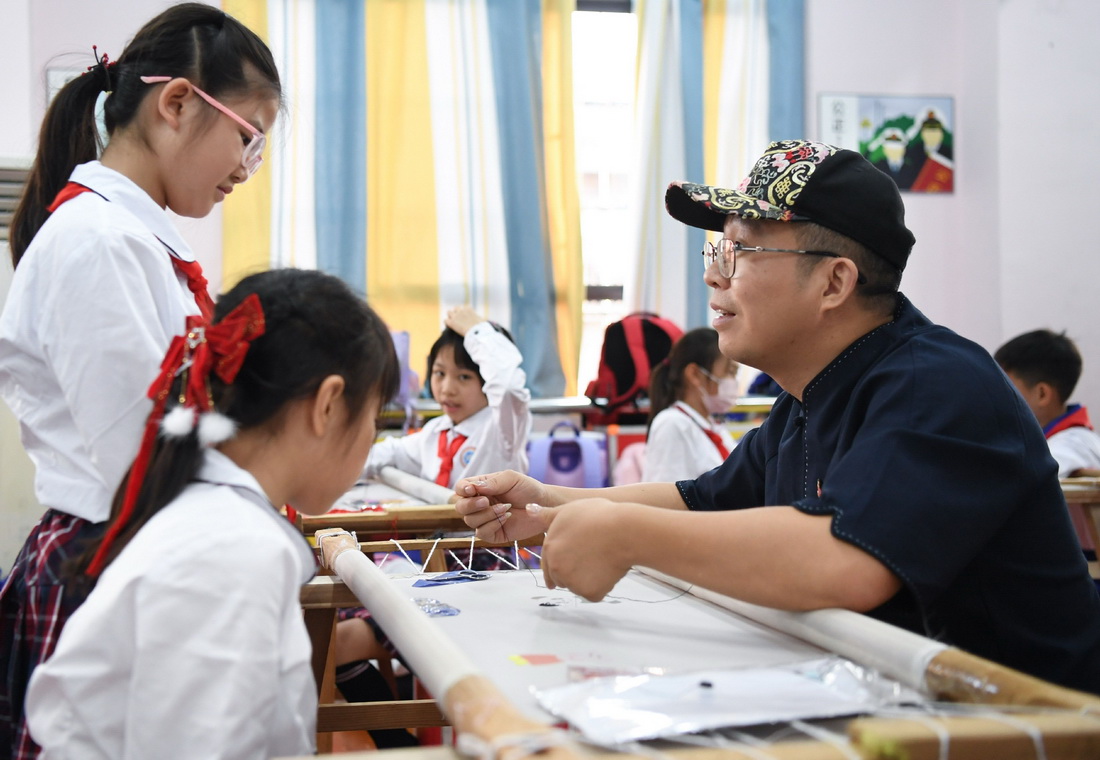 在廣州市荔灣區康有為紀念小學的廣繡課堂，王新元在指導學生（10月12日攝）。