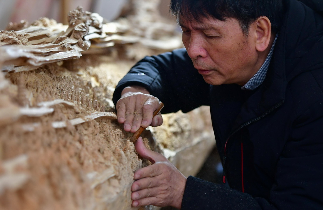 12月14日，国家级非遗项目莆田木雕省级代表性传承人郑春辉在进行雕刻。 