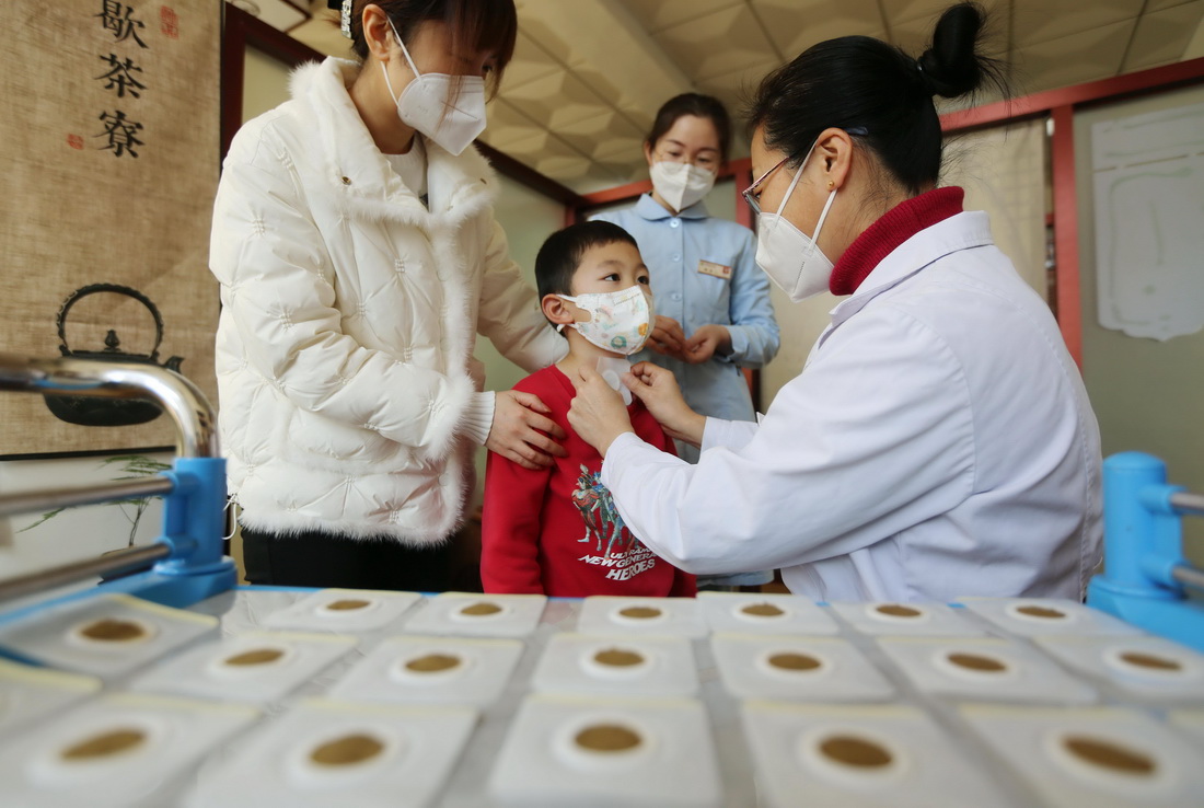 12月19日，山東省臨沂市沂南縣中醫醫院，醫生為一名兒童進行穴位貼敷療法。
