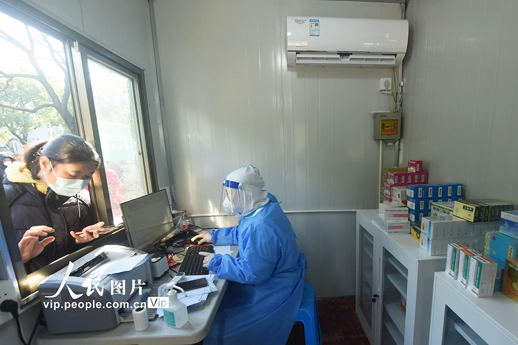 2022年12月20日，市民在杭州蕭山區一由核酸採樣點改建而成的健康診療站外進行診療。