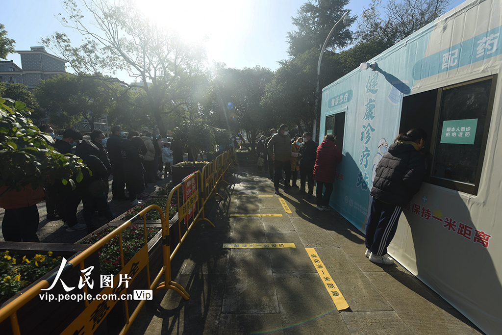 2022年12月20日，市民在杭州蕭山區一由核酸採樣點改建而成的健康診療站外排隊等待進行診療和配藥。