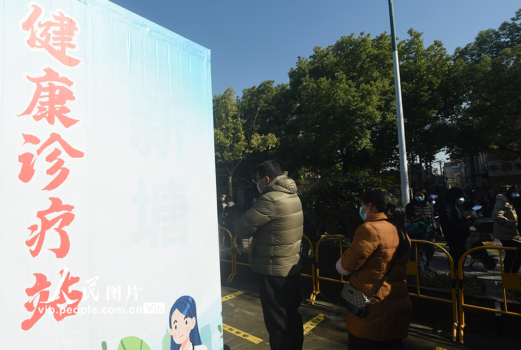 2022年12月20日，市民在杭州蕭山區一由核酸採樣點改建而成的健康診療站外排隊等待進行診療和配藥。