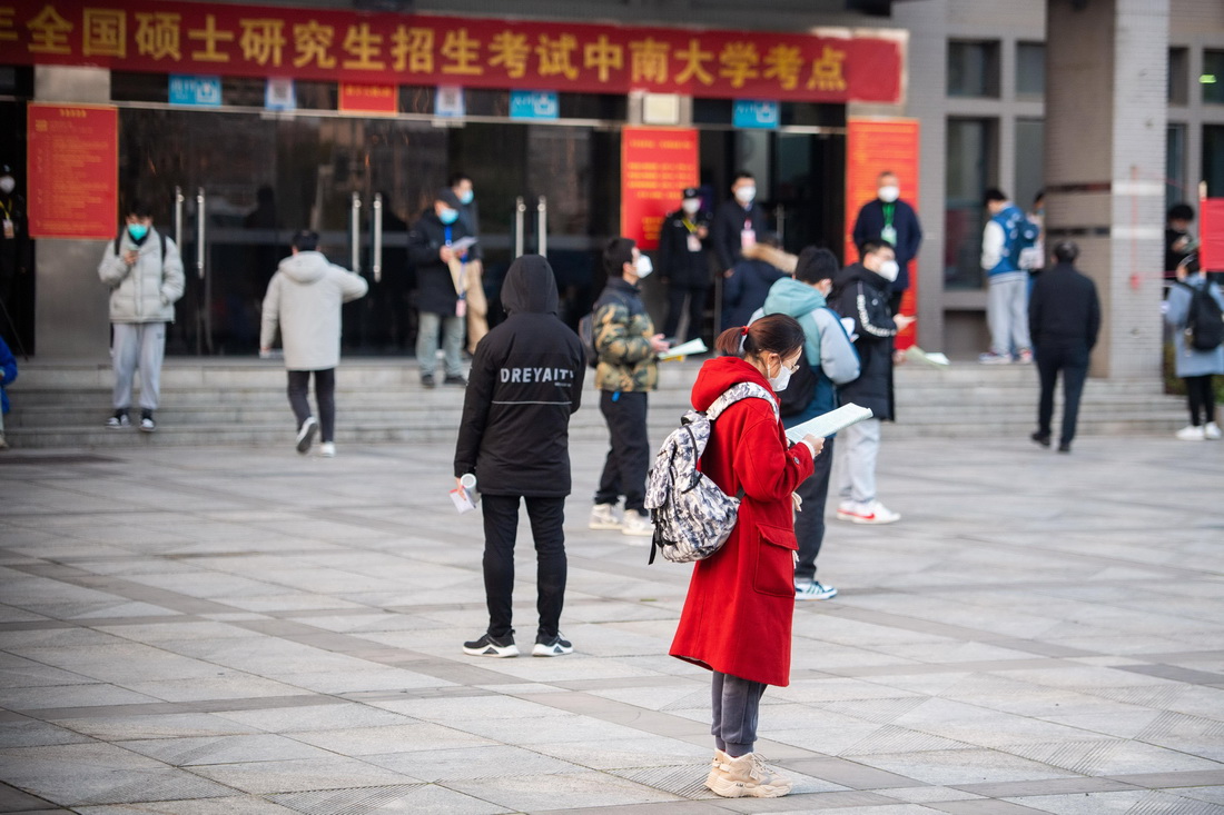 12月24日，在湖南中南大学考点，考生在考场外复习。