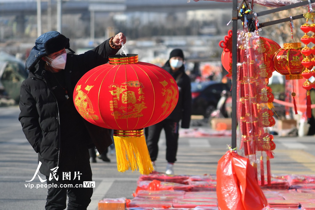 12月24日，在山东省青岛市城阳区流亭街道双埠年货大集上，市民选购红灯笼。