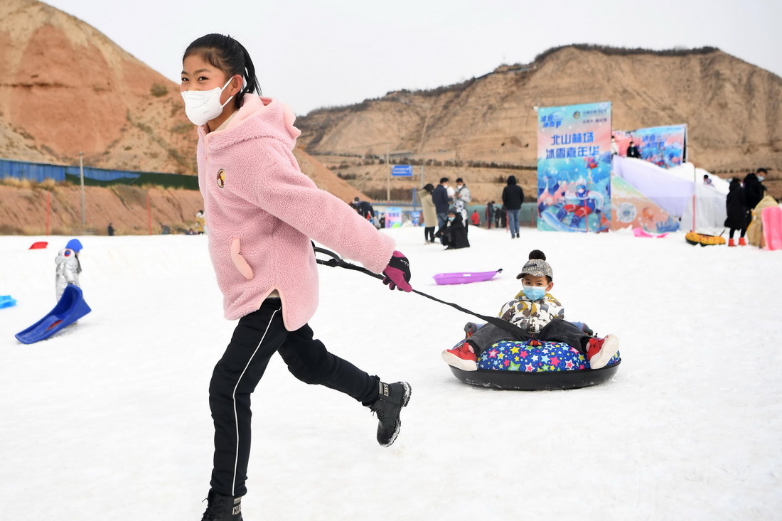 12月25日，在兰州市北山林场，游客在冰雪嘉年华上体验雪地娱乐项目。