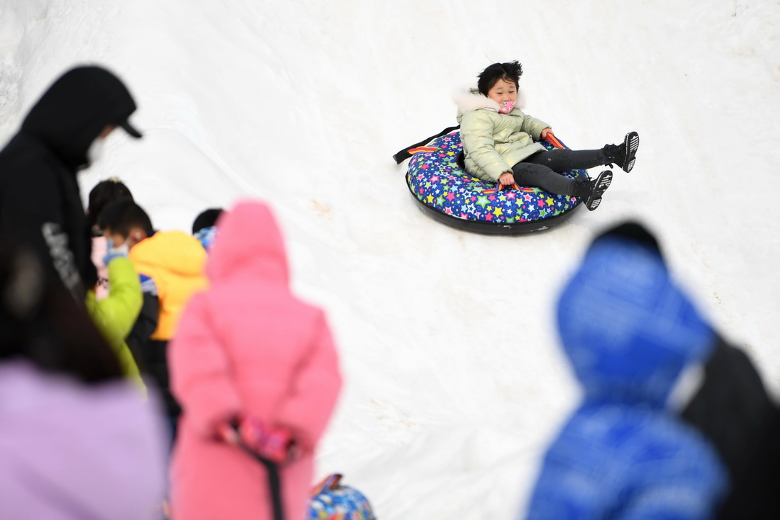 12月25日，在兰州市北山林场，游客在冰雪嘉年华上体验雪地娱乐项目。
