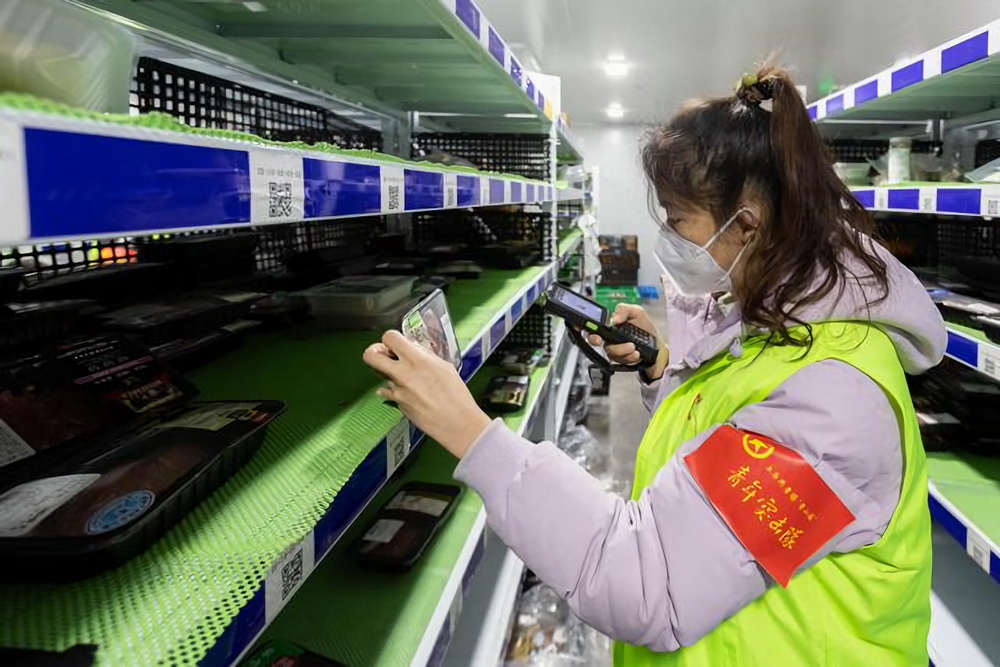 12月27日，在上海市徐匯區的美團買菜前置倉，青年突擊隊隊員掃碼商品條形碼，確定商品是否匹配。
