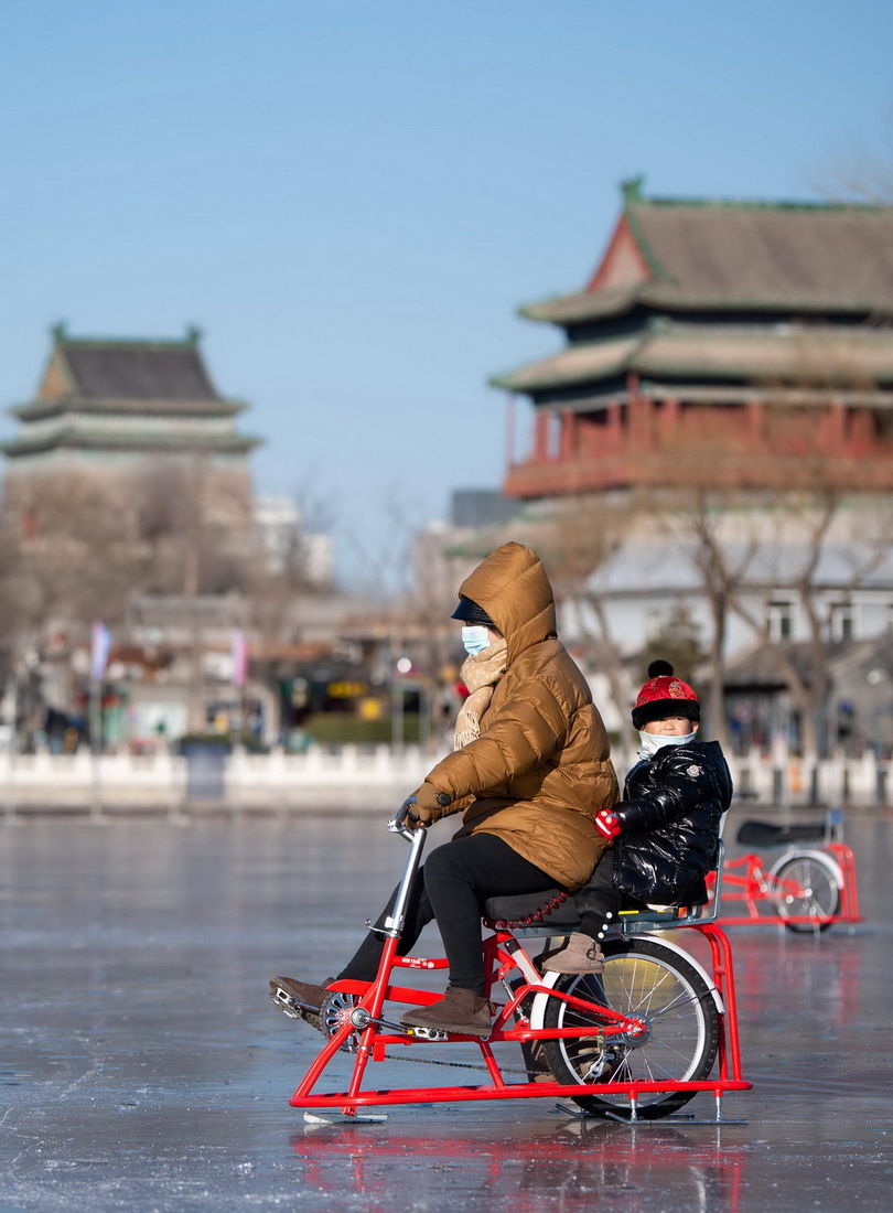 12月27日，家長帶著小朋友在北京什剎海冰場上騎冰上自行車。