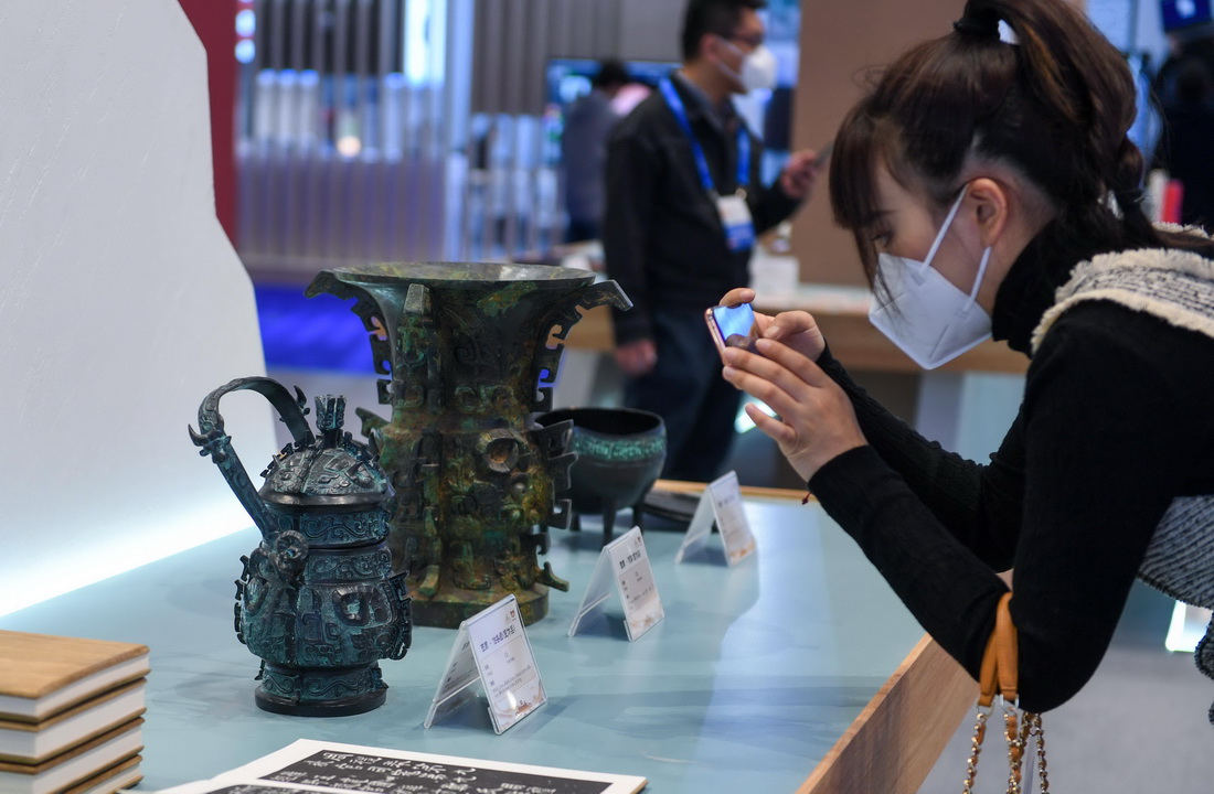 12月29日，参观者在中国国家版本馆展区拍摄文创产品。