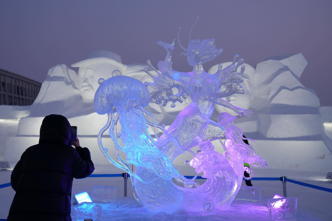 1月6日，在哈尔滨冰雪大世界园区内，游客拍摄冰雕作品《舞者》。 新华社记者 王建威 摄