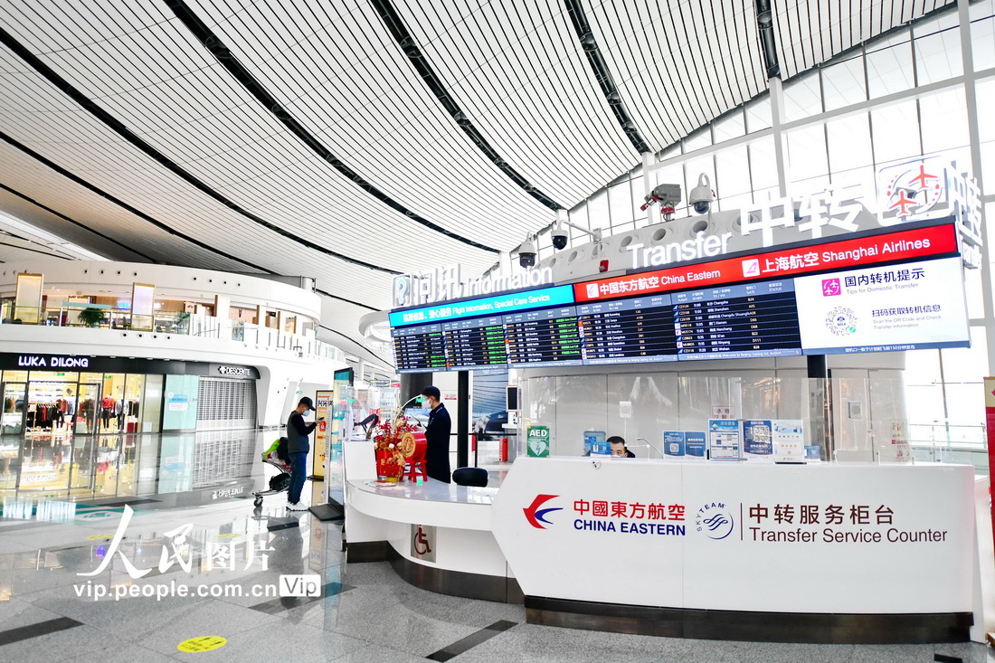 2023年1月7日，大兴国际机场航站楼国内出发层，乘客在中转服务柜台办理转机业务。