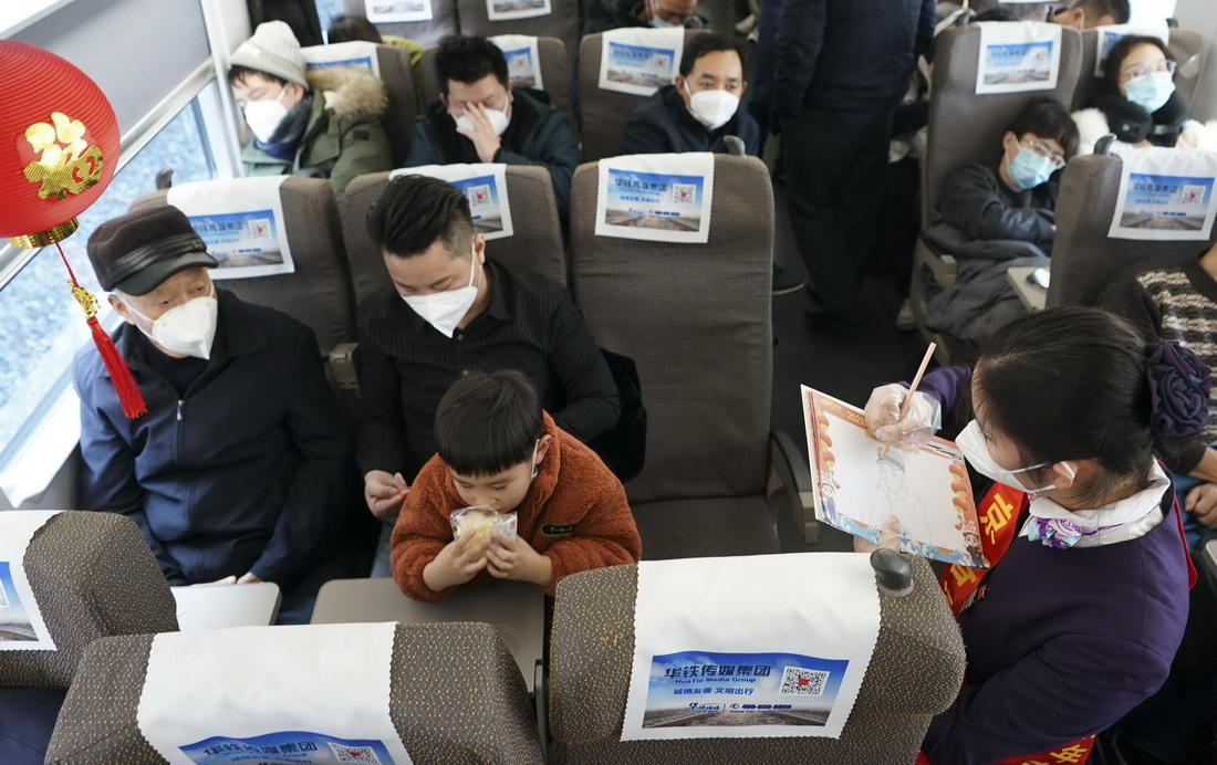 1月11日，在D376次列車上，列車員梁靜璐為旅客作畫。 新華社發（景宗興 攝）