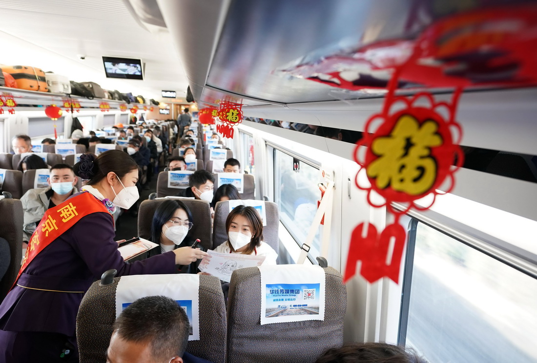 1月11日，在D376次列車上，列車員張文靜給旅客送上畫作。新華社記者 季春鵬 攝