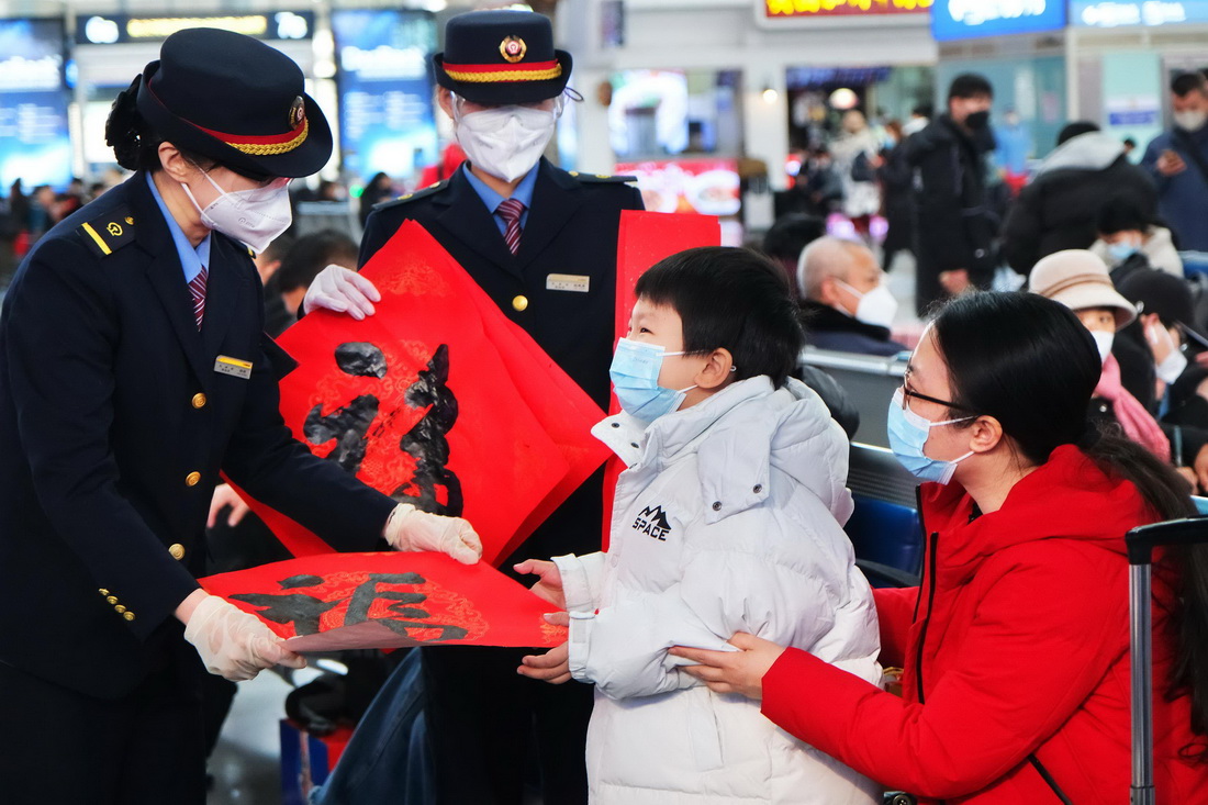 1月14日，天津站工作人员在候车大厅为旅客送上福字。