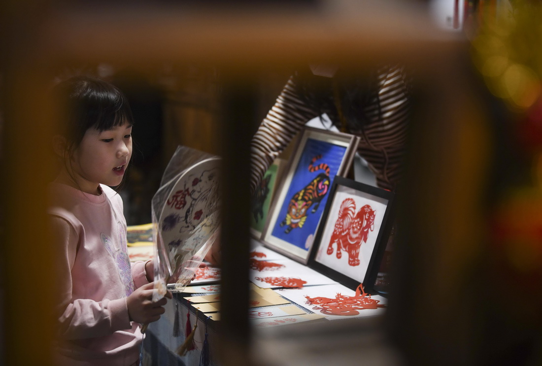 在烏魯木齊市博物館內，一名小朋友在參觀展出的非遺項目剪紙作品（1月14日攝）。