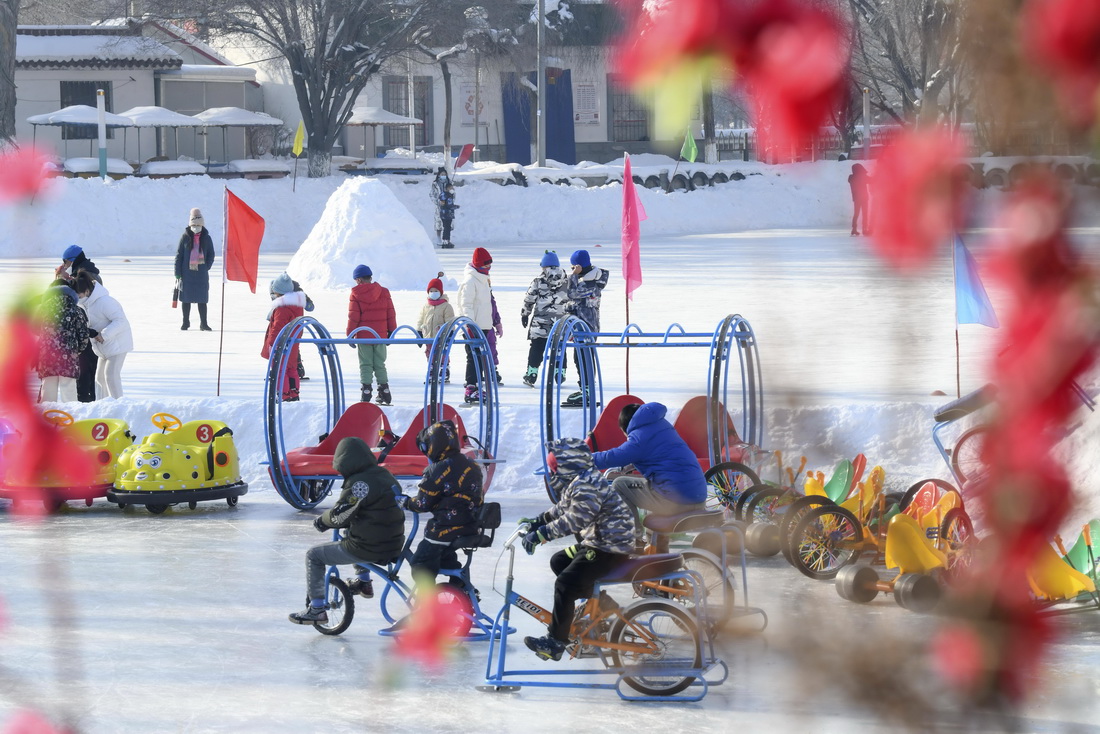 1月15日，小朋友們在烏魯木齊紅山公園冰場上玩耍。