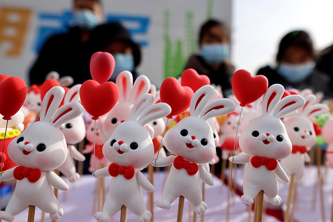 1月15日，人們在山東省棗庄市齊村大集上選購面塑“萌兔”。新華社發（孫中喆 攝）