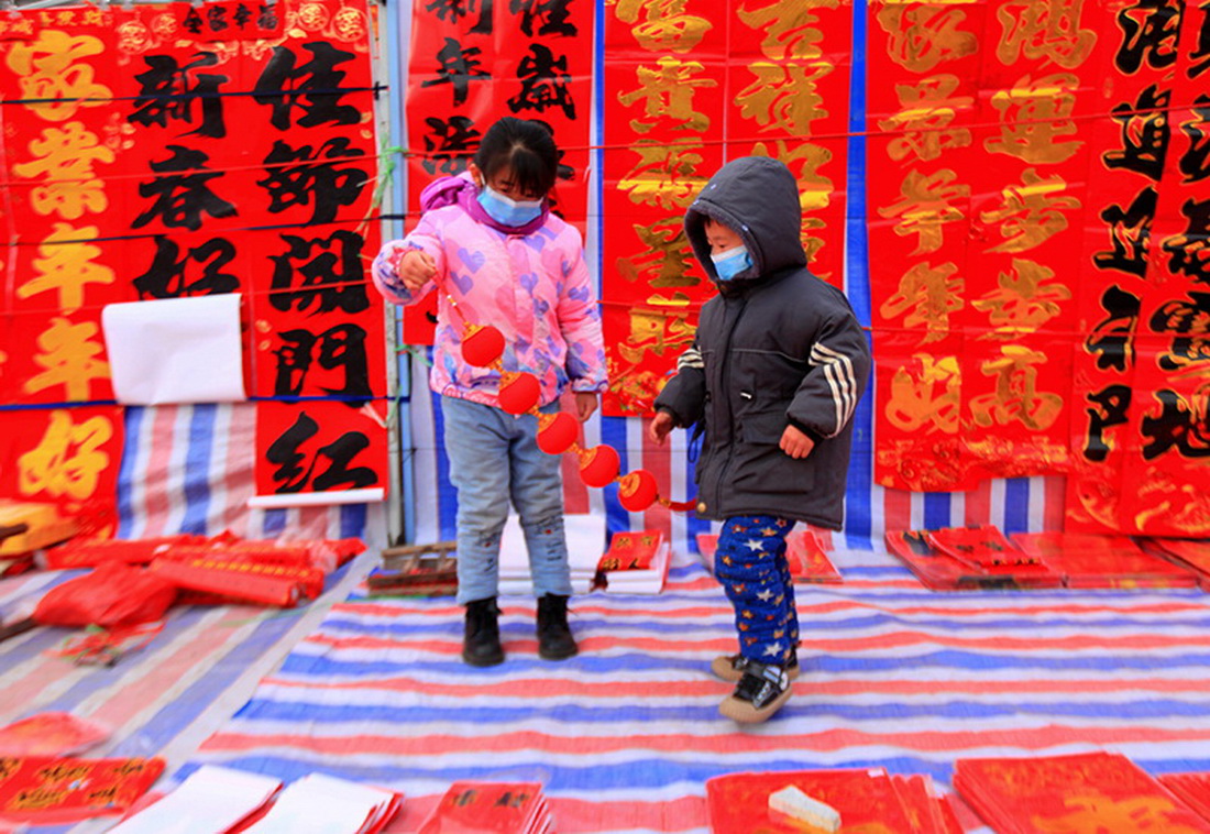 1月15日，小朋友在山東省臨沂市平邑縣地方鎮年貨大集上玩耍。新華社發（武紀全 攝）