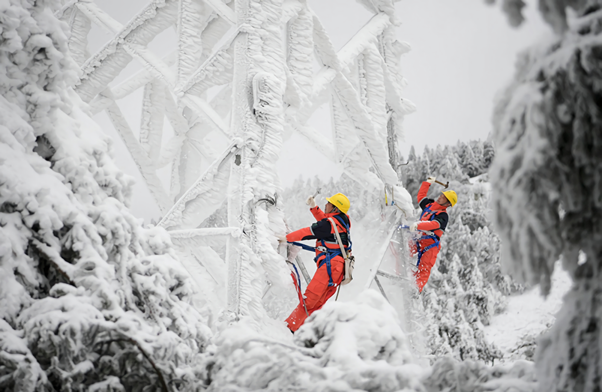 1月17日，在湖北省鹤峰县山区，应急抢险人员在铁塔上除冰雪。
