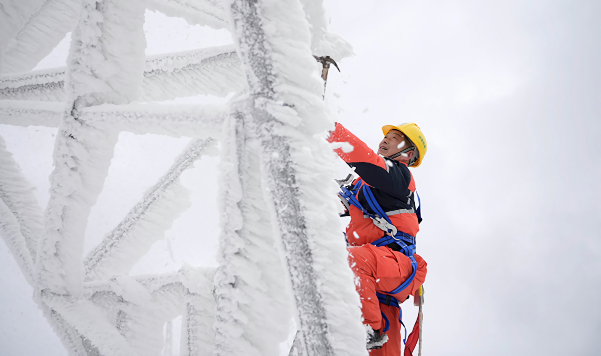 1月17日，在湖北省鶴峰縣山區，應急搶險人員在鐵塔上除冰雪。