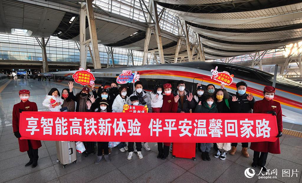 1月18日，由北京南站開往上海虹橋的G5次復興號智能動車組列車乘務人員與旅客在站台上合影留念。