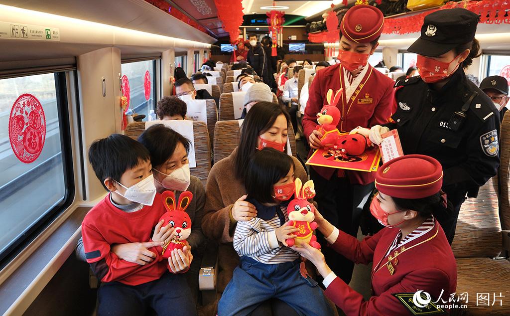 1月18日，在G5次復興號智能動車組列車上乘務人員為回家過年的旅客送上福字和兔年吉祥物。