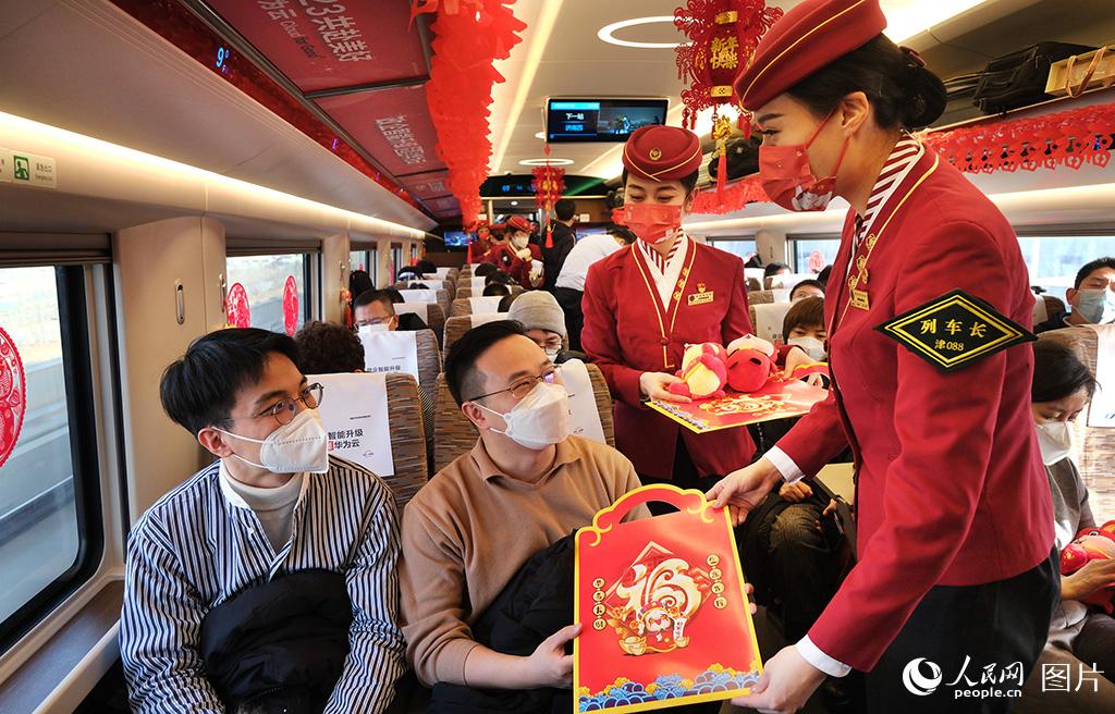 1月18日，在G5次復興號智能動車組列車上乘務人員為回家過年的旅客送上福字和兔年吉祥物。