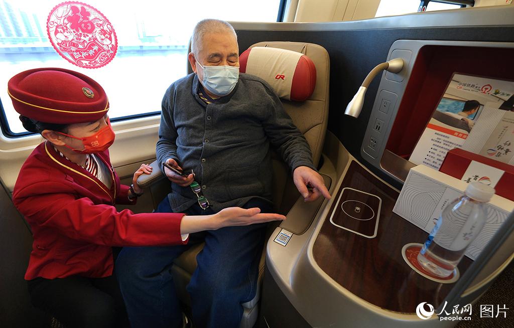 1月18日，在G5次復興號智能動車組列車上乘務人員在商務艙為旅客指導如何使用新設備。