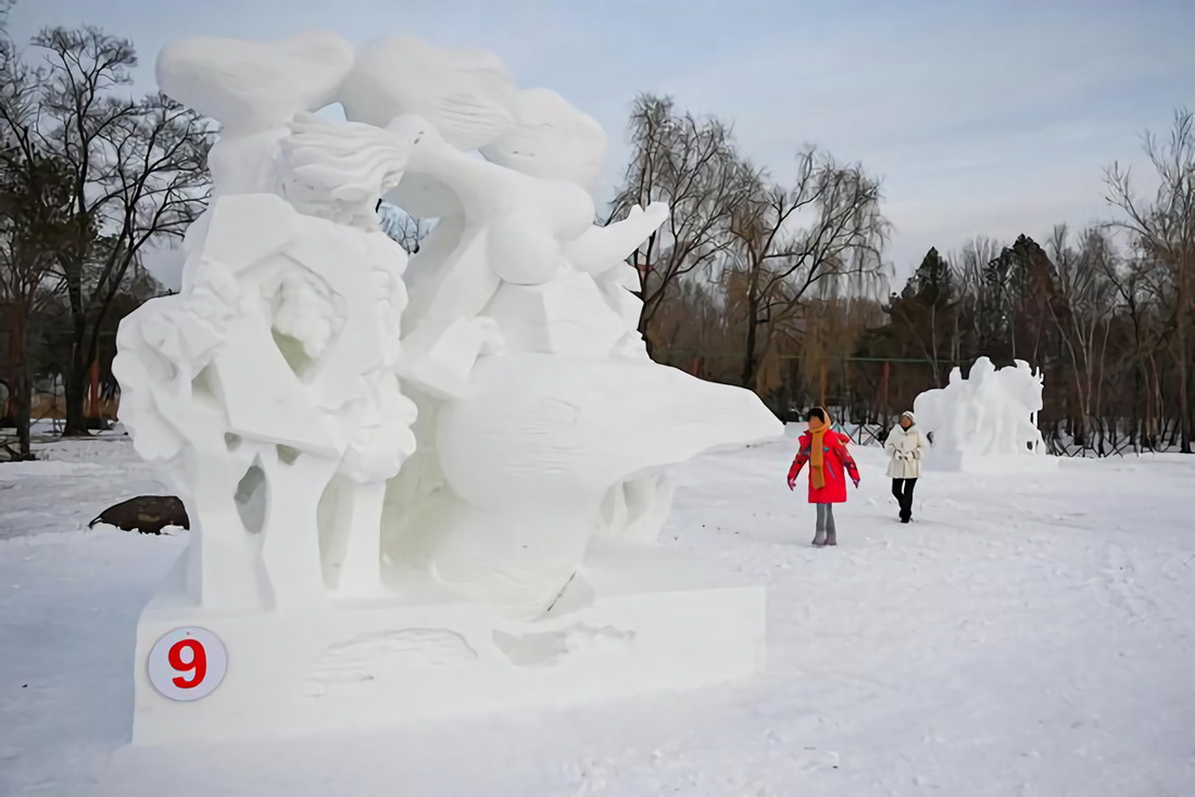 1月18日，在哈爾濱太陽島雪博會園區，游客觀賞參賽雪雕作品。