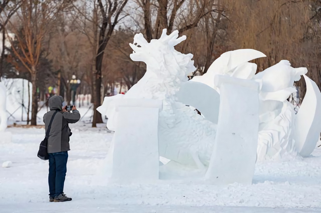 1月18日，在哈爾濱太陽島雪博會園區，游客觀賞參賽雪雕作品。