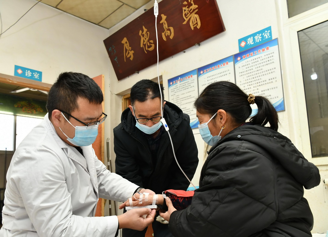 1月20日，南洋阳（左一）在村卫生室内为村民输液。
