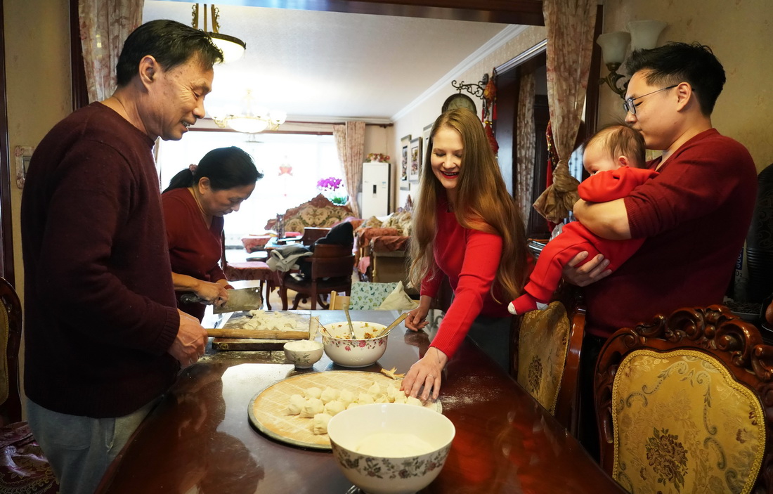 1月21日，來自德國的張珍妮（左三）與丈夫張鼎然（右一）在北京的家中和家人一起包餃子。新華社記者 任超 攝
