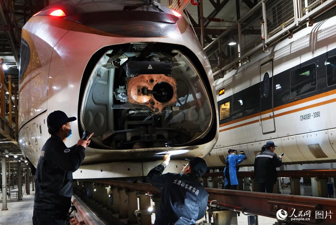 1月21日，機械師正在對進庫的動車組列車牽引部位進行檢修作業。