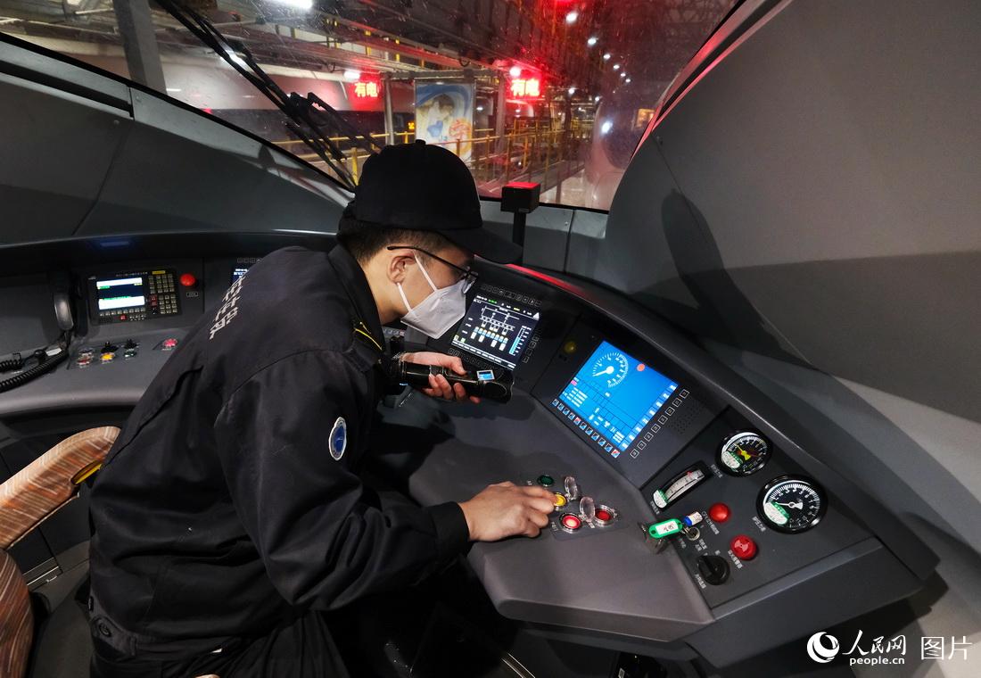 1月21日，機械師正在對進庫的動車組列車司機駕駛部位進行檢修作業。