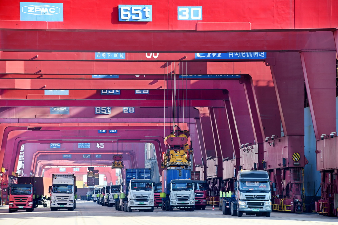 1月27日，在青島港前灣集裝箱碼頭，貨車排隊運送集裝箱。