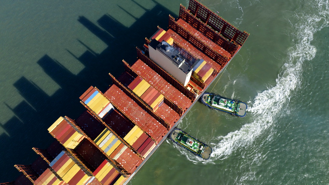 1月27日，一艘集裝箱貨輪在拖輪協助下靠泊青島港前灣集裝箱碼頭（無人機照片）。