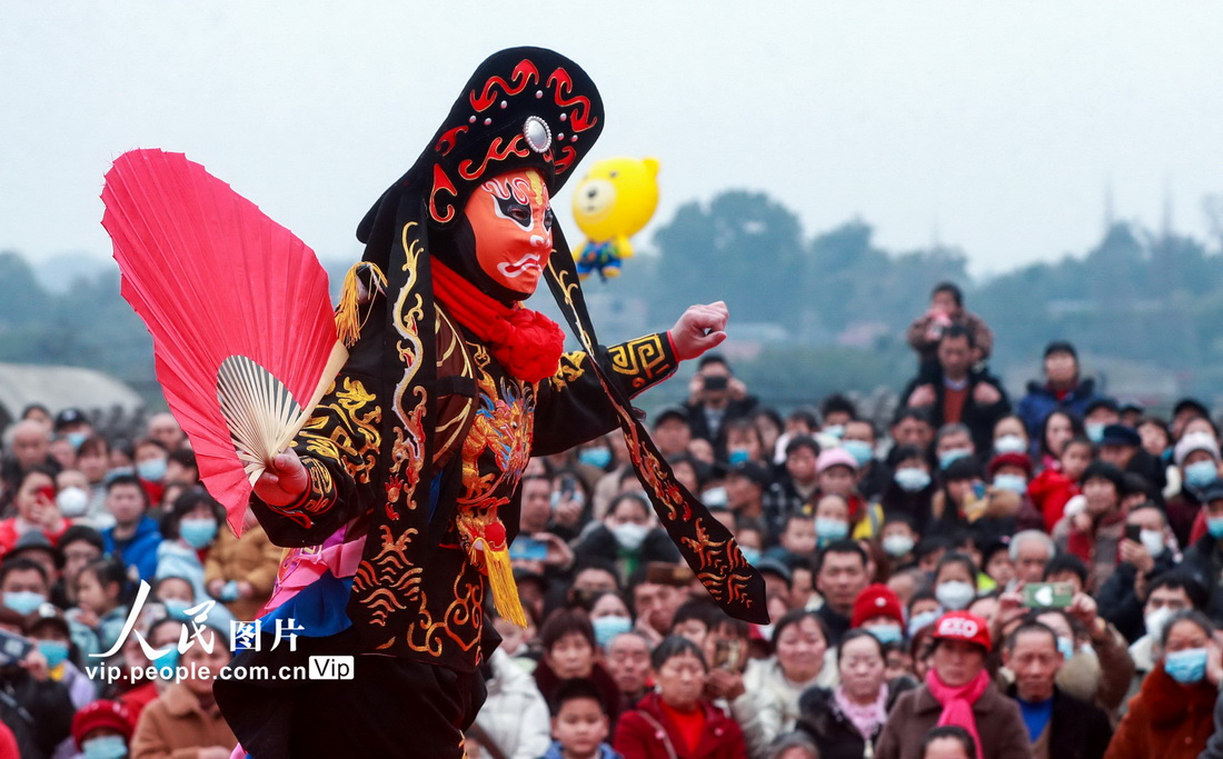 2023年1月28日，在四川省瀘州市江陽區鄰玉街道文化廣場上，市民和游人在觀看川劇絕活“變臉”表演。