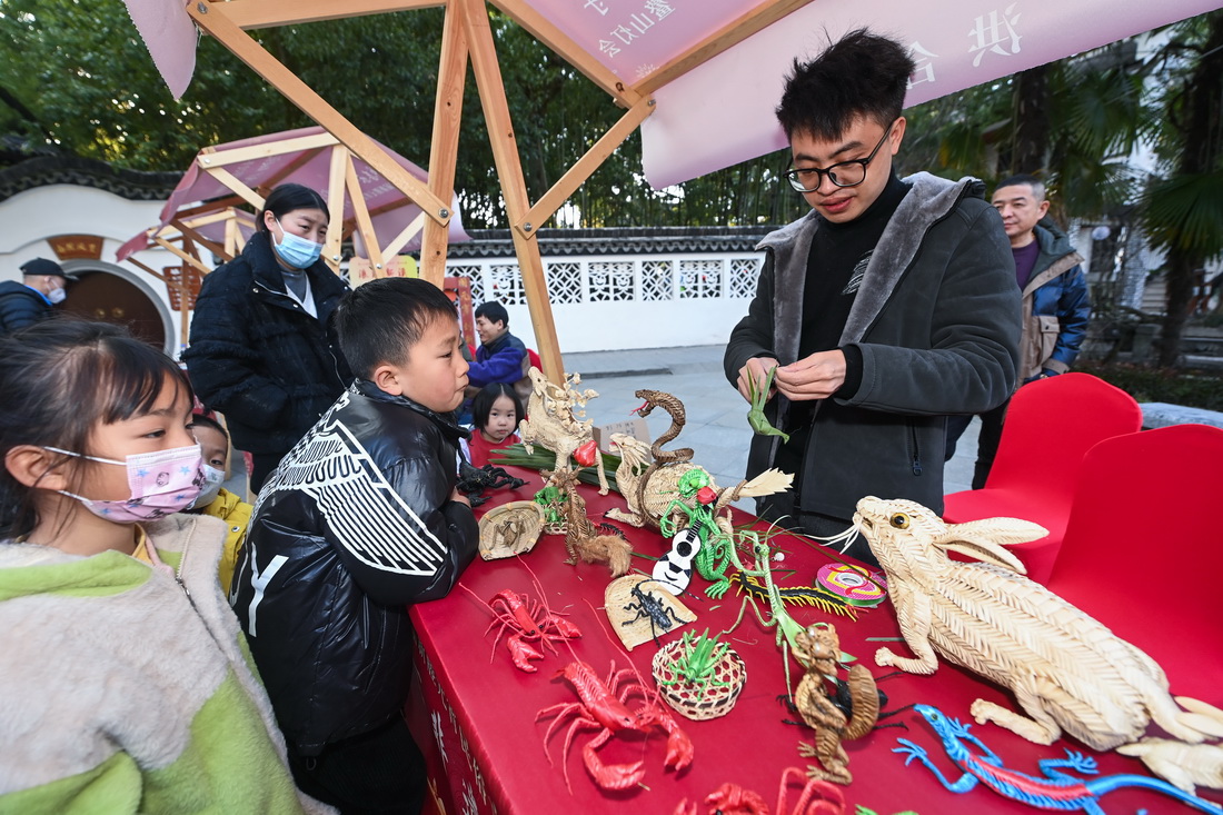 1月29日，在嘉興市秀洲區新塍古鎮小蓬萊公園內，傳統藝人（右）在“鰲山燈會”現場展示手工技藝。