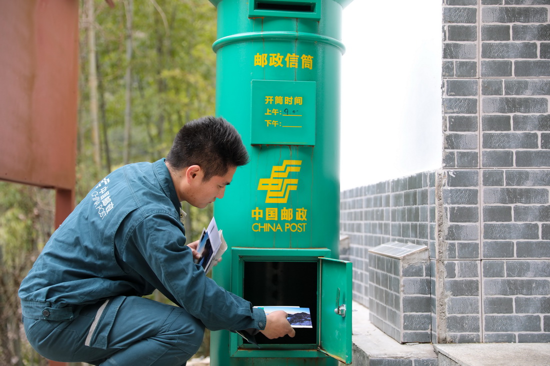 2月1日，謝菲俊取出郵政信筒裡游客寄往各地的明信片等。