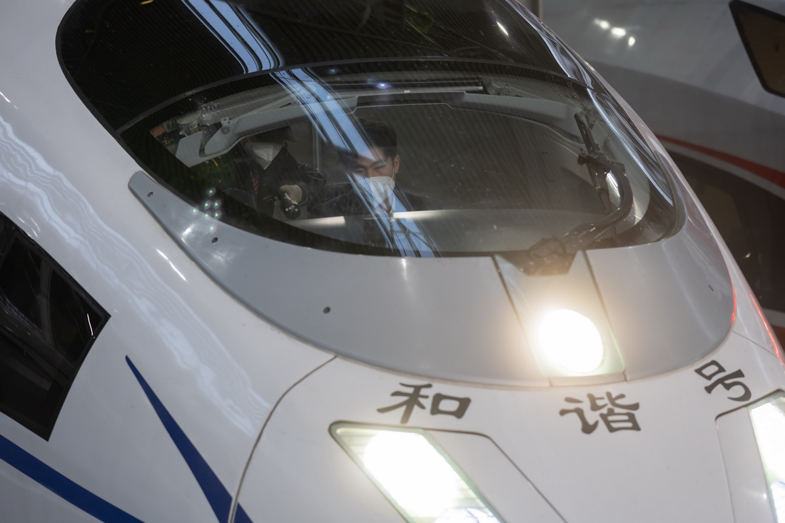 2月1日早晨6时40分许，DJ7715次高铁确认列车完成既定线路任务后返回上海站，上海机辆段司机陈逸东（右）和上海动车段随车机械师吴家乐（左）在司机室交接。